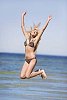 Woman jumping for joy on the beach