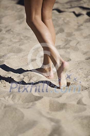 Female feet on the beach sand