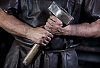 Male hands holding a blacksmiths hammer