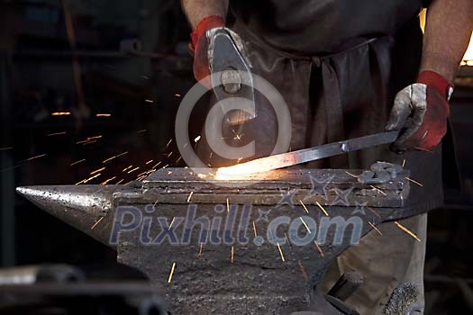 Hot iron being hammered at the blacksmith shop Hot iron being hammered at the blacksmith shop