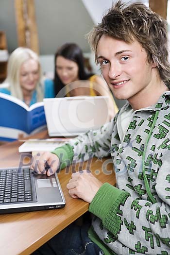 Male teenager with a laptop in the classroom