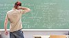 Male teenager thinking in front of the blackboard