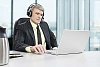Businessman sitting behind his desk, listening to music