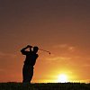 Male golfer at the golfcource on the sunset