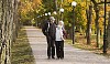 Elderly couple walking together in autumn park