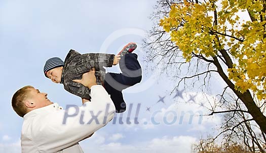 Father and son playing in autumn park Father and son playing in autumn park