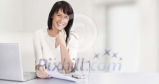 Business woman by her desk with laptop and mobile