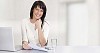 Business woman by her desk with laptop and mobile