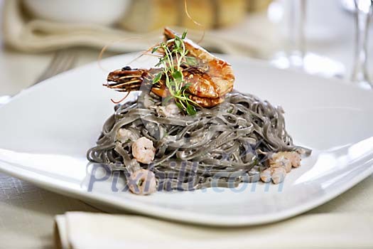 Exotic black pasta with sea food in restaurant