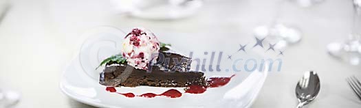 Piece of chocolate cake and ice cream ball on plate