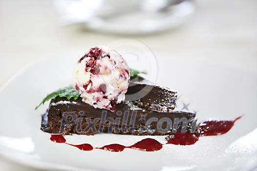 Piece of chocolate cake and ice cream ball on plate