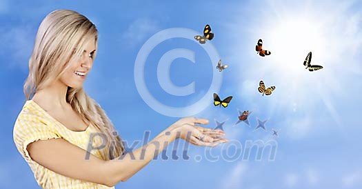 Beautiful girl setting free a bunch of colorful butterflies