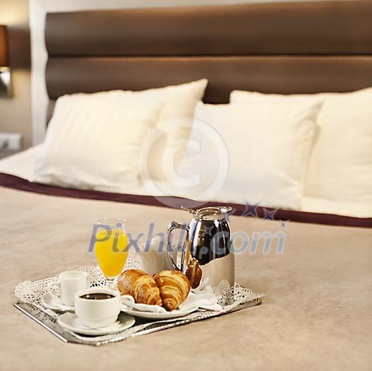 Breakfast tray on a hotel bed, served by room service Breakfast tray on a hotel bed, served by room service