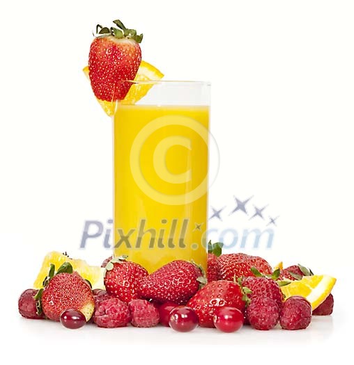 Glass of orange juice surrounded by red berries