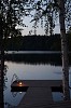 Evening dusk and lighted pier by a calm lake