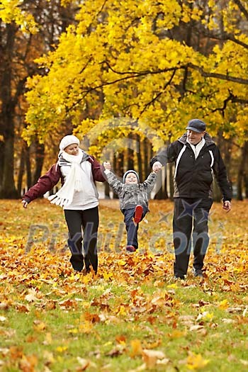 Older couple walking in park with their grandson