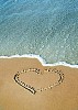Heart on the sand near water