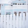 Out of focus house behind a white picket fence
