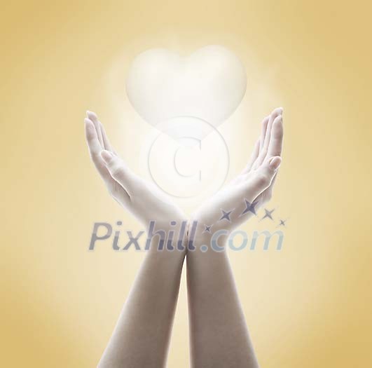 Hands with shining heart on a beige background