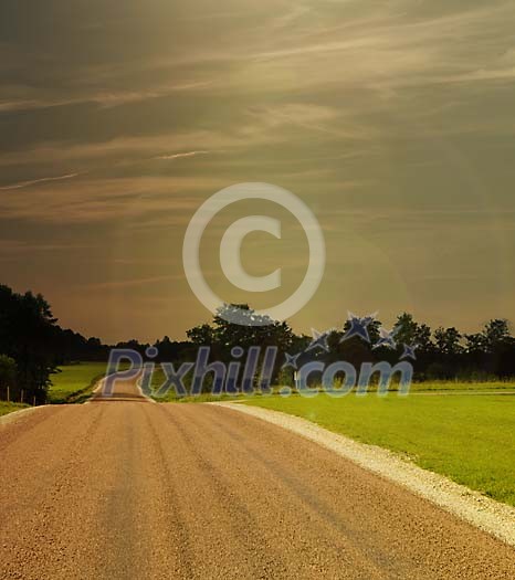 Empty country road next to the green field