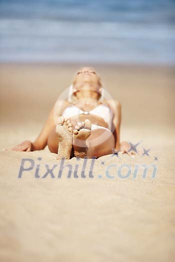 Woman bathing in the sun on a sandy beach