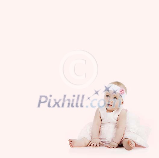 Baby girl in dress sitting on a pink background Baby girl in dress sitting on a pink background