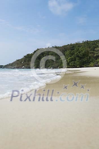 Empty beach with green hill on the background at Koh Samet, Thailand