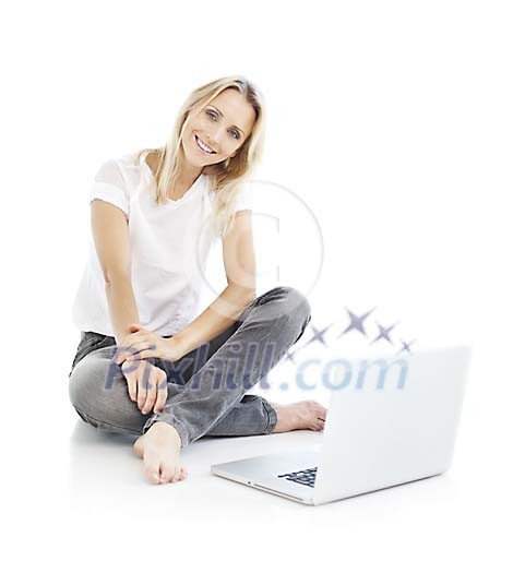Pretty woman sitting on the floor next to the laptop