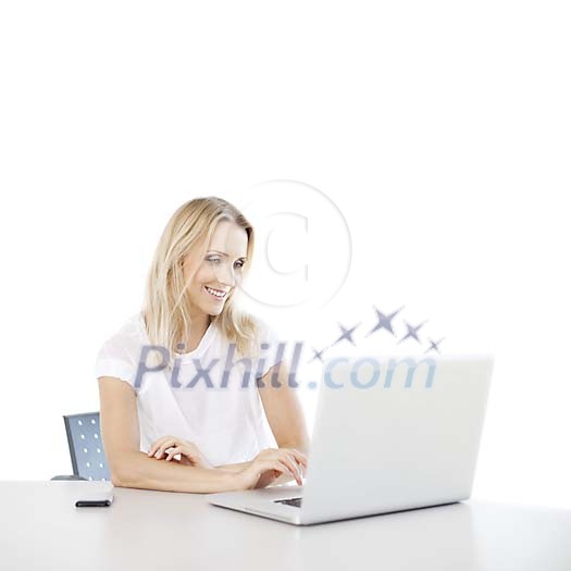 Woman sitting by the desk working on the laptop