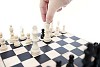 Hand lifting a queen on chessboard