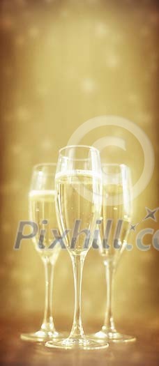 Three glasses of champagne on a golden background