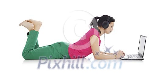 Woman on the floor with laptop, listening to music
