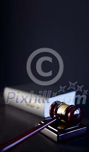 Gavel with a law book on a dark background