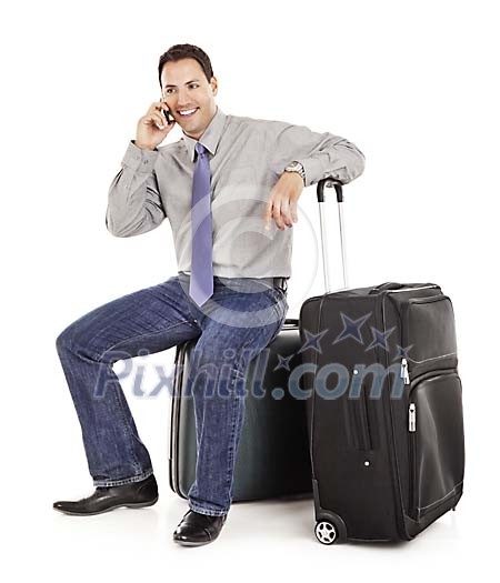 Clipped man sitting on the suitcase and talking to a phone