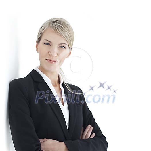Businesswoman leaning to the wall and looking at the camera