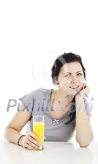 Woman sitting by the table, drinking juice