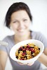 Defocused woman offering a bowl of cornflakes