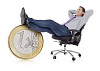 Businessman sitting and resting his feet on a oversized euro coin