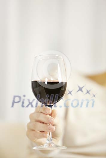 Hand holding a glass of red wine