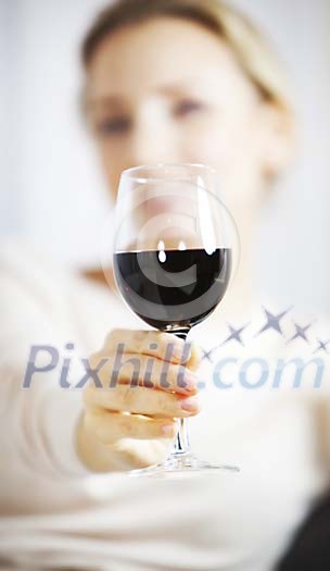 Hand reaching a glass of wine to the camera Hand reaching a glass of wine to the camera