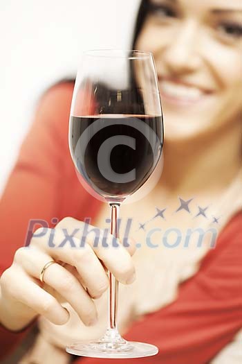 Woman holding a glass of red wine close to the camera