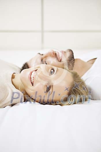 Man and woman on the bed, smiling