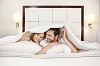 Couple hiding under the blanket on the bed