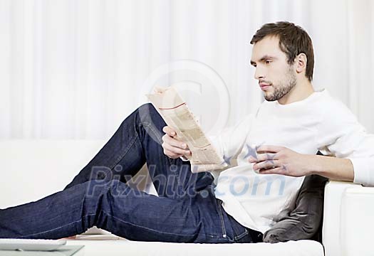 Man reading newspaper on the sofa