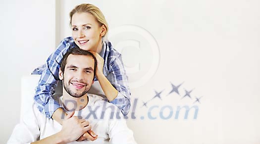 Man sitting on the chair and woman standing behind him Man sitting on the chair and woman standing behind him