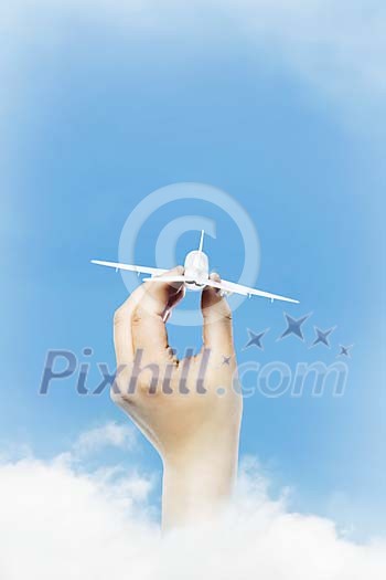 A travelling conceptual with hand holding airplane in the sky