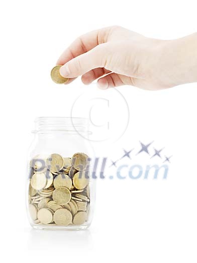 Isolated hand putting a coin in the glass jar