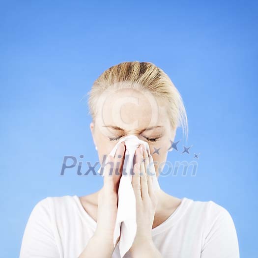 Woman sneezing on a blue background