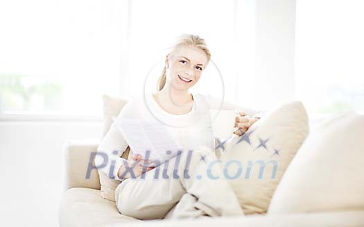 Woman on the couch reading and drinking tea