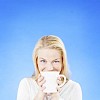 Woman on a blue background drinking coffee